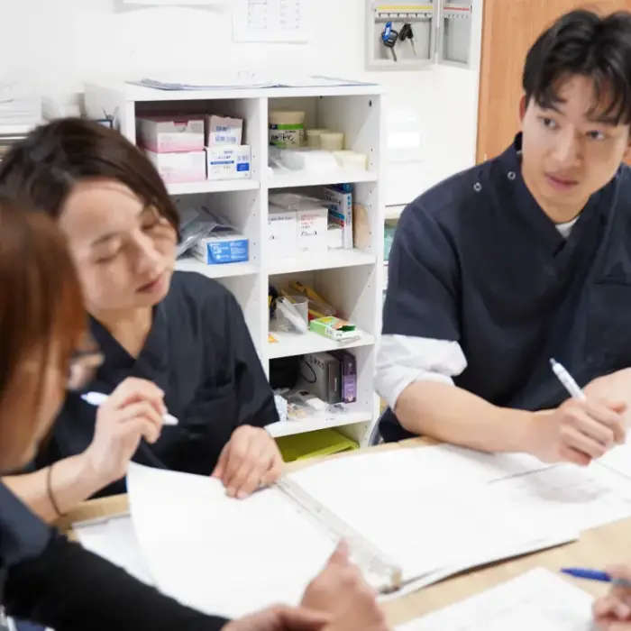 資料を広げて話し合う3人の看護師