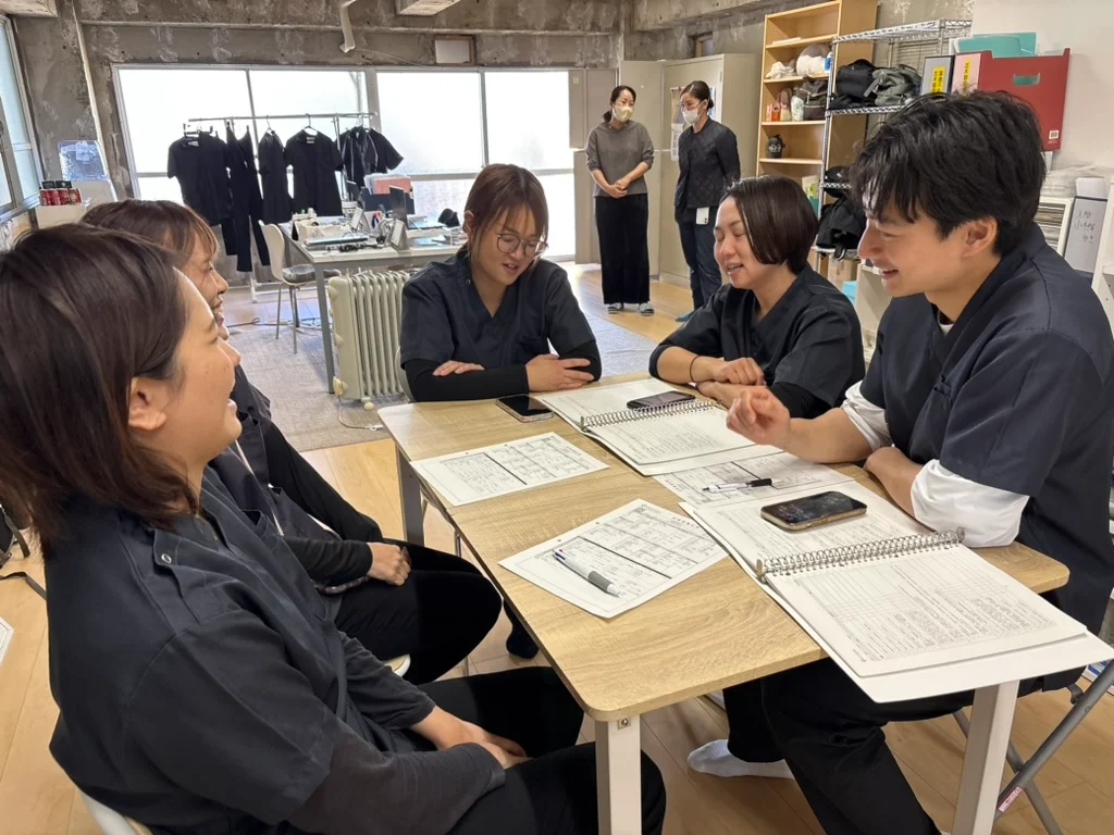 テーブルを囲んで笑いながら話すトータルケアの看護師たち