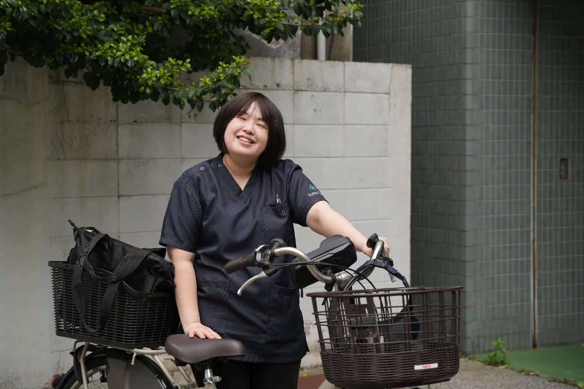 自転車を押して訪問に出るトータルケア練馬の看護師 Sui Yano