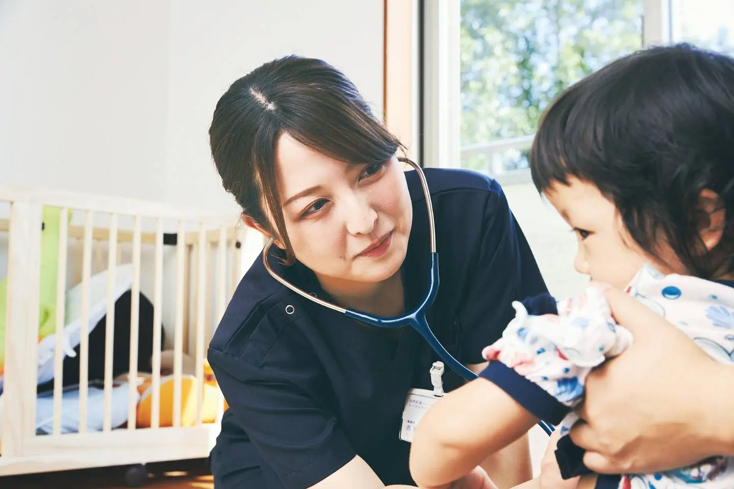 小児の訪問看護でお子さんに聴診器をあてる看護師